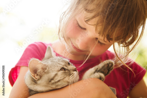 Happy child with cat outdoors.


