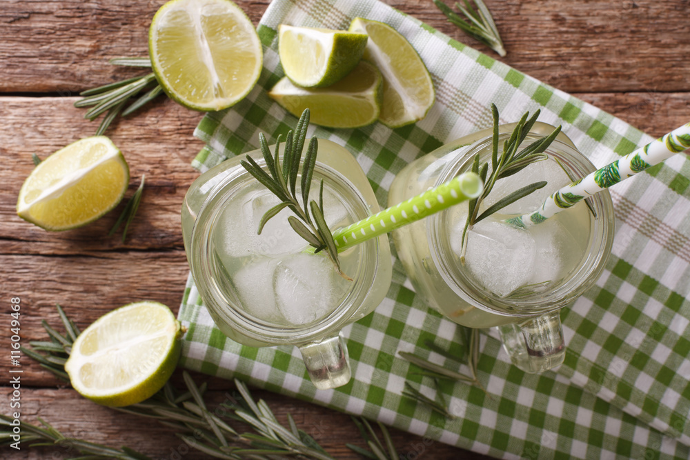 Cold cocktail with lime, ice and rosemary close up in a jar. horizontal top view
Cold cocktail with lime, ice and rosemary close up in a jar. horizontal top view