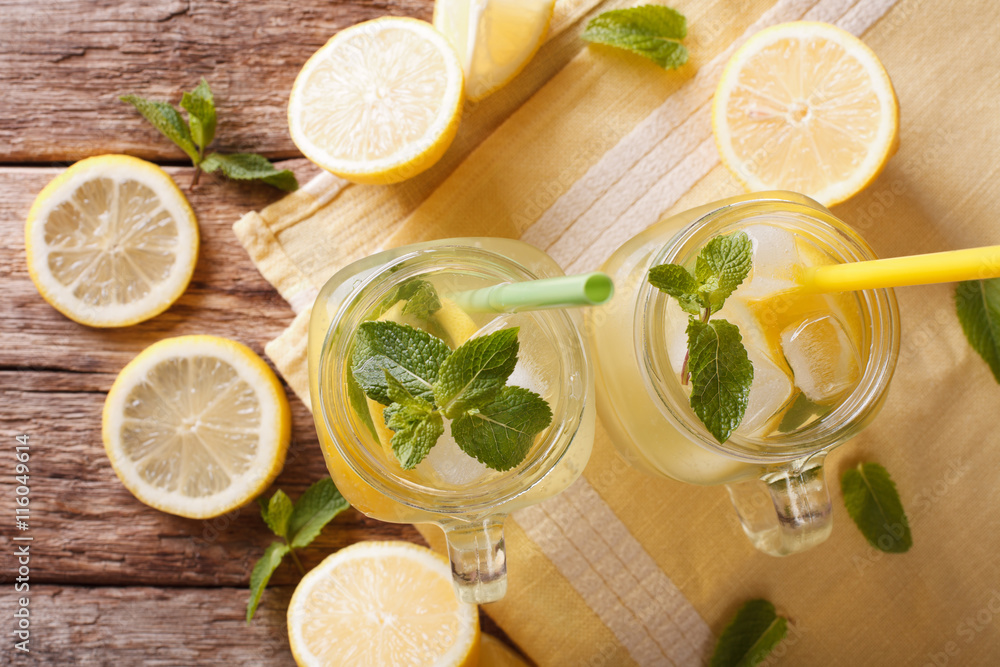 Homemade lemonade with ice and mint close up in a glass jar. Horizontal top view
Homemade lemonade with ice and mint close up in a glass jar. Horizontal top view
