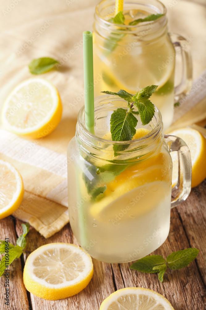 Classic lemonade with ice and mint close up on the table. vertical
Classic lemonade with ice and mint close up on the table. vertical