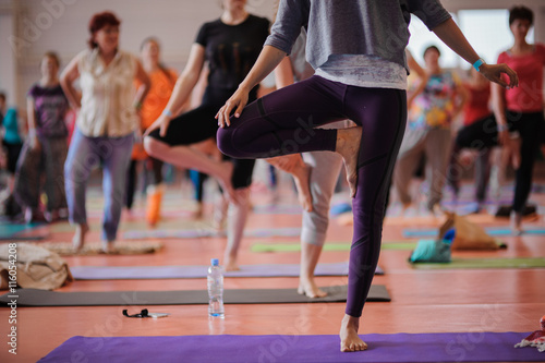 Women practicing yoga at health club