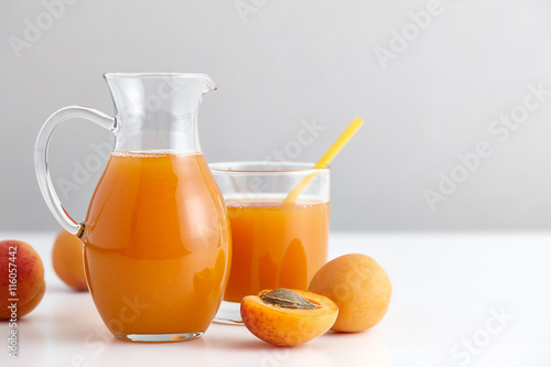 Ripe apricots and a glass jug with fresh juice