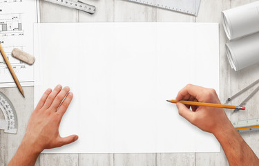 Drawing project on blank white paper. Top view scene with arhitect equipment arranged around the paper.