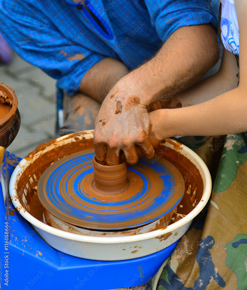 Potter teaches to sculpt a baby from clay on a Potter's wheel Potter teaches to sculpt a baby from clay on a Potter's wheel