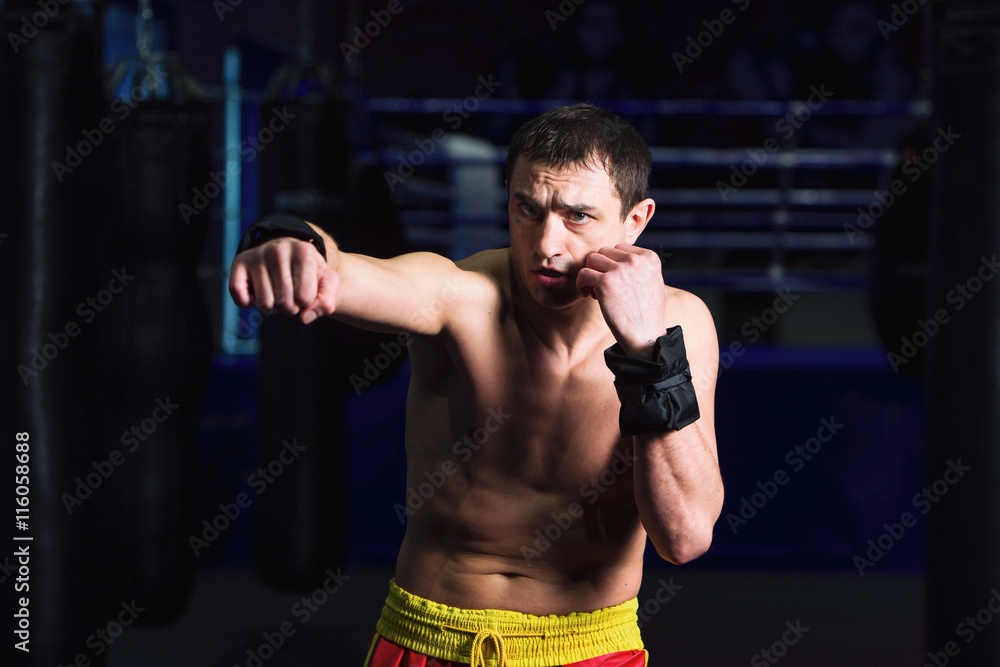 Sports: man kickboxer is practicing kick in a boxing gym Sports: man kickboxer is practicing kick in a boxing gym