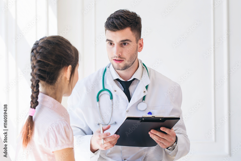 Pediatrician doctor examining little girl in a clinic Pediatrician doctor examining little girl in a clinic
