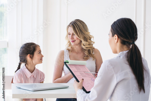 Tablou pe pânză Doctor consulting family pregnant mother with daughter in a hospital