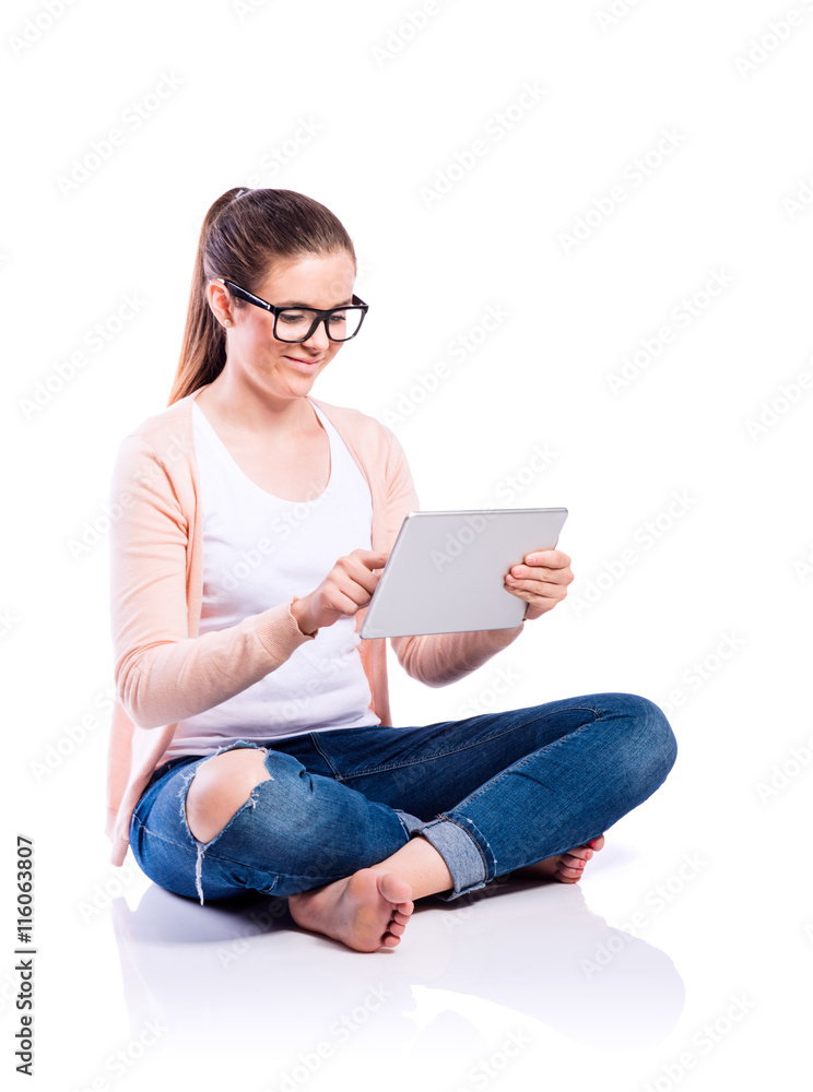 Woman with tablet sitting on the floor, studio shot, isolated Woman with tablet sitting on the floor, studio shot, isolated