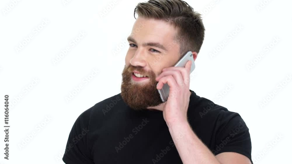 Young handsome smiling bearded man talking on the phone Young handsome smiling bearded man talking on the phone