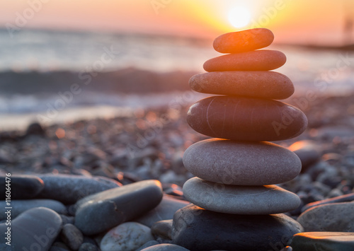 Pebbles pyramid on beach in sunset time