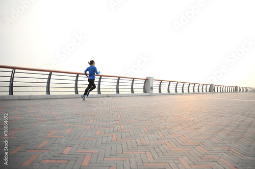 young fitness woman runner athlete running at seaside road