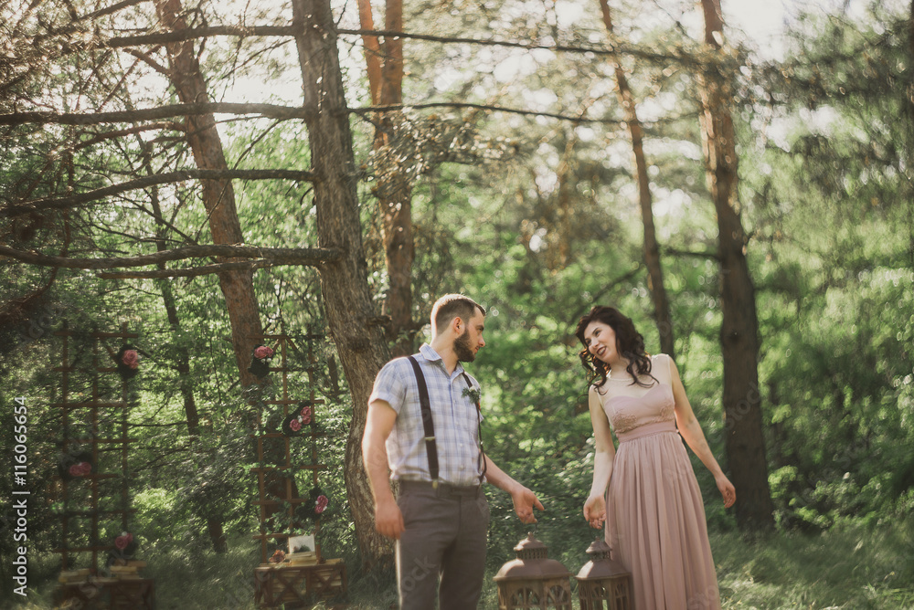 stylish couple pose in the sunlight wood near decor zone. Blurred and haze stylish couple pose in the sunlight wood near decor zone. Blurred and haze