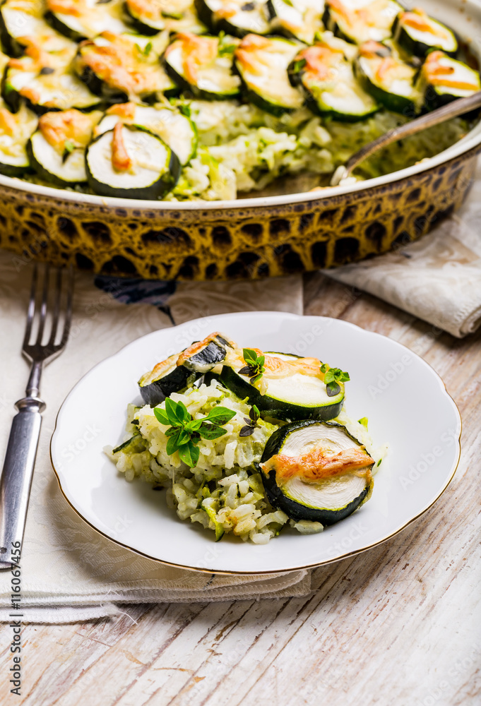 Casserole with zucchini, rice and cheese served with fresh basil Casserole with zucchini, rice and cheese served with fresh basil