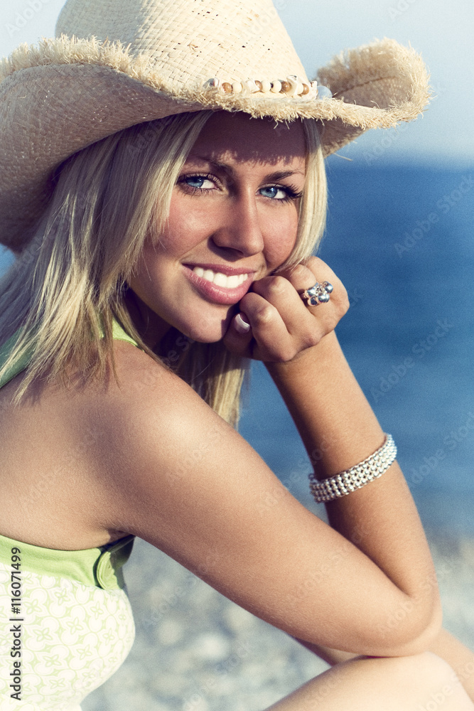 Beautiful Young Woman on a Beach in Straw Cowboy Hat Stock Photo