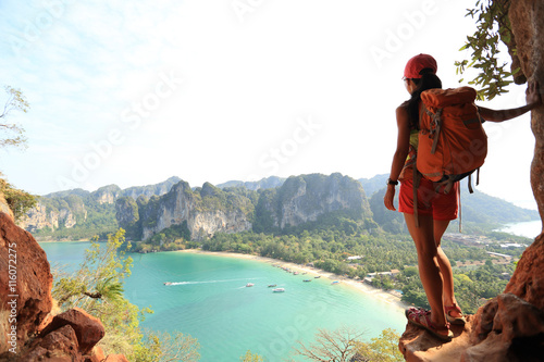young woman backpacker hiking on seaside photo