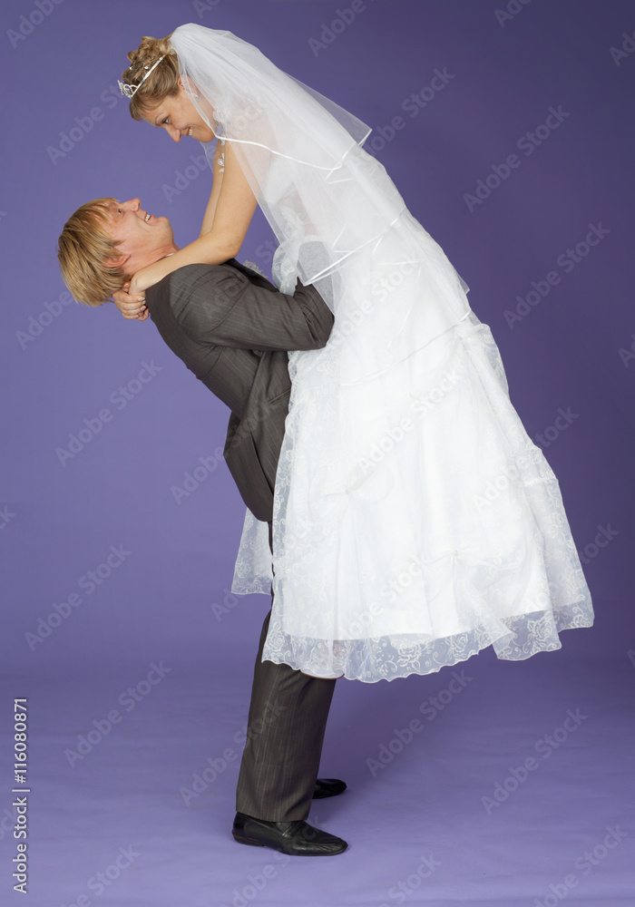 Strong groom holds admired bride on hands Strong groom holds admired bride on hands