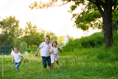 Three children run a race in the park