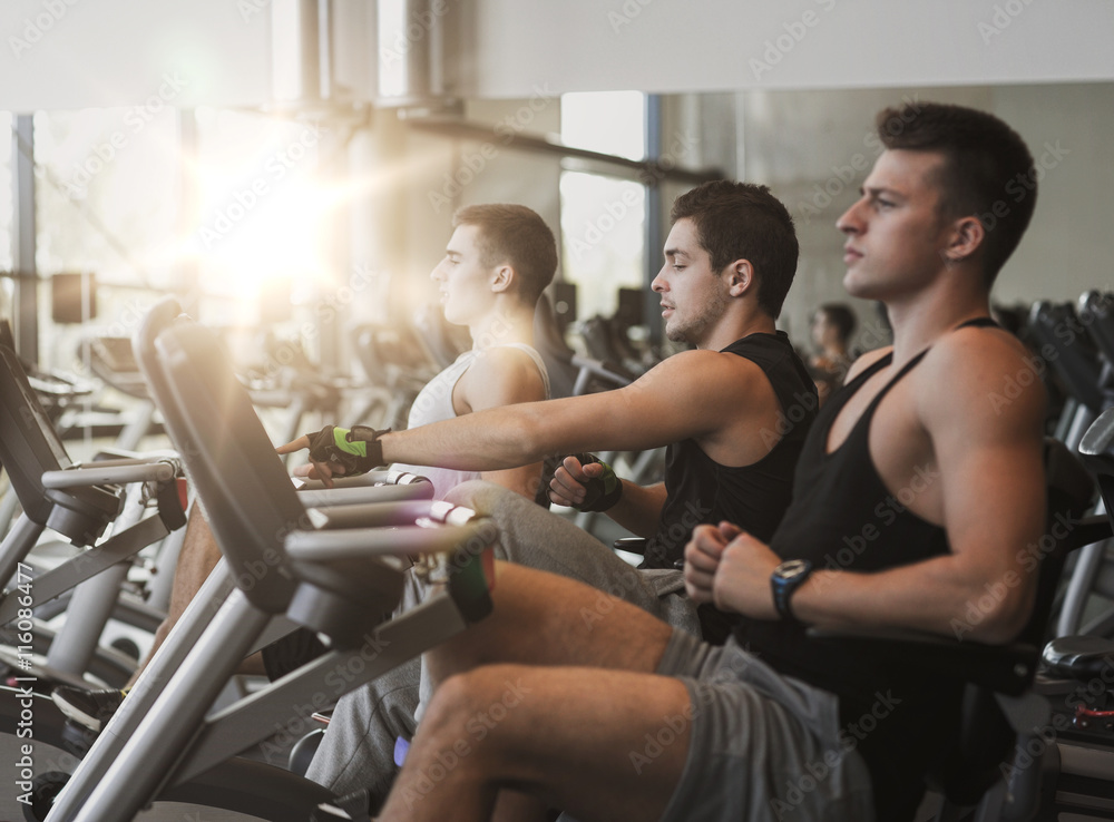 men working out on exercise bike in gym men working out on exercise bike in gym