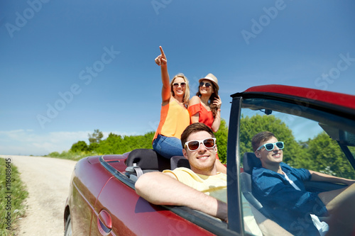 happy friends driving in cabriolet car at country © Syda Productions