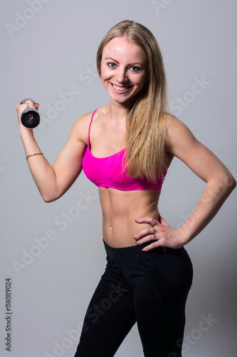 Portrait of smiling beautiful girl with dumbbells