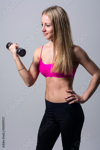 Portrait of a beautiful girl with dumbbell. © kanzefar