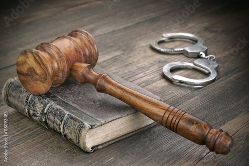 Judges Gavel, Handcuffs and Law Book In Courtroom