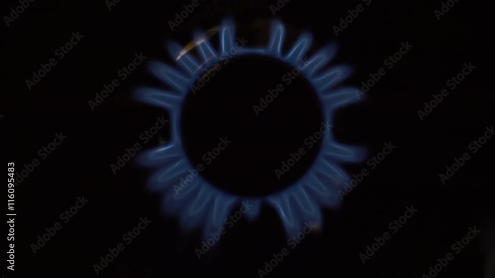 In the kitchen stove ignited the fire in the burner on a black background. View from above. Slow motion, high speed camera, 250fps In the kitchen stove ignited the fire in the burner on a black background. View from above. Slow motion, high speed camera, 250fps
