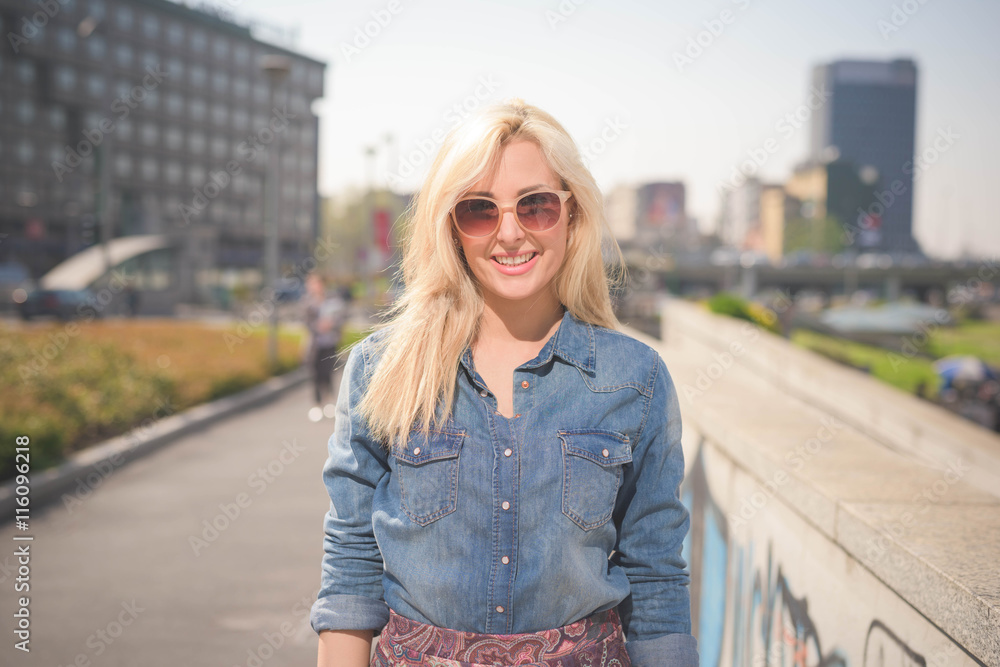 Young beautiful caucasian blonde girl in the city