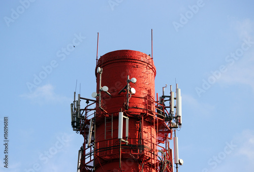 Red and white tube boiler with cables of telecommunications equipment, primarily for cellular transmission photo