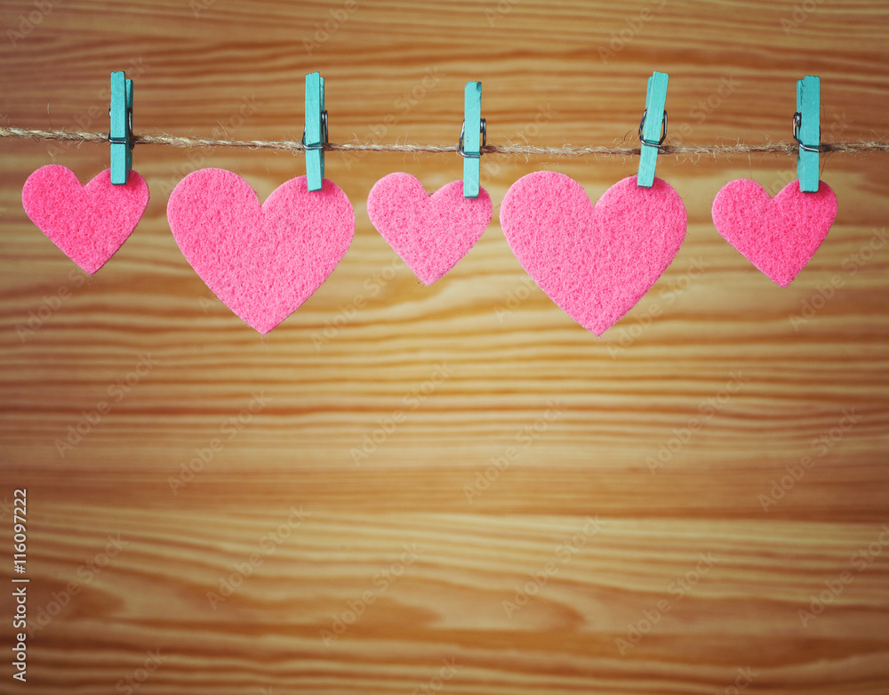 Fototapeta premium five pink hearts hanging on a cord 