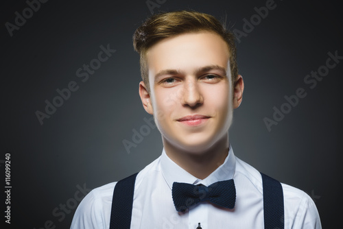 Happy boy. Closeup Portrait of handsome teenager smiling isolated on grey background