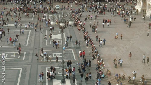 People walking, taking a stroll in Piazza Duomo square, Milan, Italy
