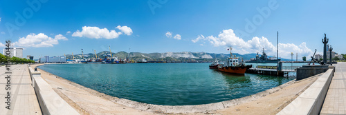 Panoramic view of Tsemes bay, port and sea-front in Novorossiysk, Russia. The inscription on the pier is "Boat trips"