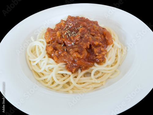 Spaghetti bolognese on a plate isolated on the black background