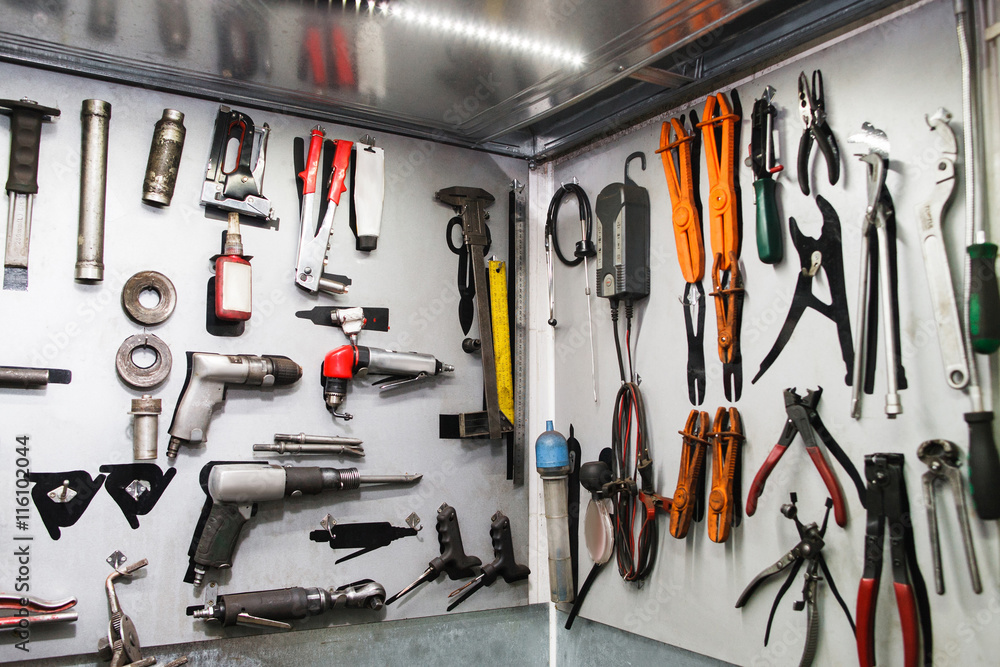 Assorted instruments for car maintenance on wall at service. Special tools  for professional vehicle repairing Stock Photo