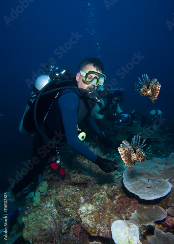 Scuba diver looks at Lion fish