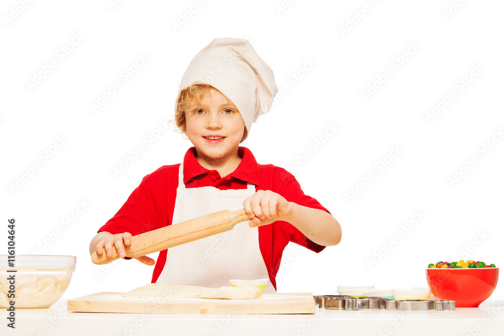 Young baker making dough with rolling pin Young baker making dough with rolling pin