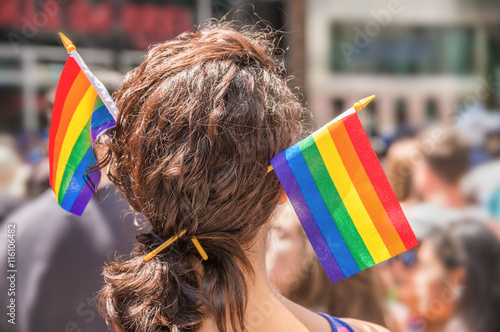 Photography A female spectator with two rainbow flag hair sticks is watching Toronto gay par