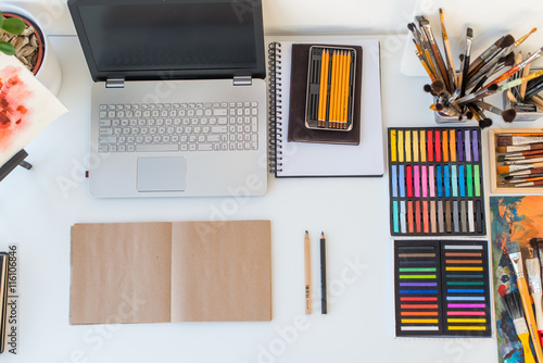 Designer workplace top view. Painter desk with drawing equipment. Home studio for artist.