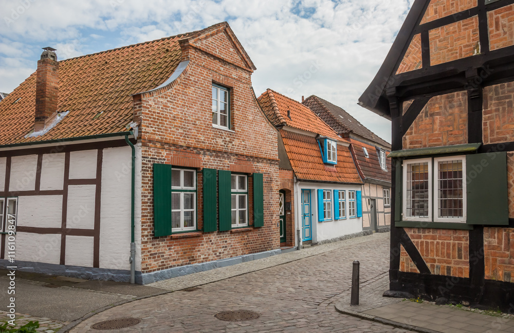 Narrow cobblestoned street with small houses in Travemunde Narrow cobblestoned street with small houses in Travemunde
