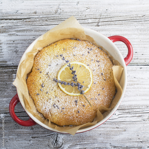 Delicate fragrant homemade cream pie with biscuit crumbs decorated  a slice of lime and lavender flowers on wooden background. The idea  baking  decorating. selective Focus photo