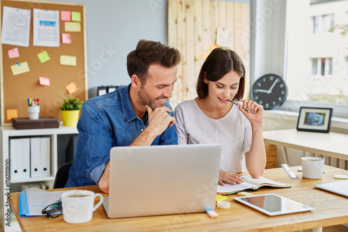 Young couple working together, analysing financial data at offic