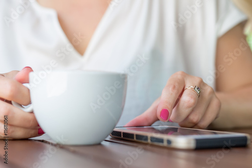 Close up of hands woman using her cell phone in restaurant