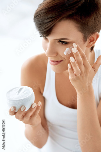 Fotografie Beauty Skin Care. Beautiful Woman Applying Cosmetic Face Cream