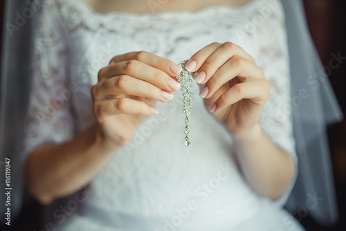 Bridal preparation for the wedding ceremony. bride putting on jewelry