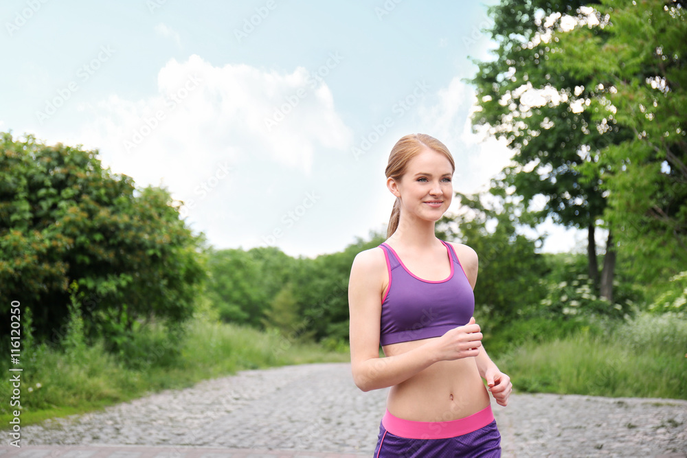 Sporty woman jogging at park on a sunny day Sporty woman jogging at park on a sunny day