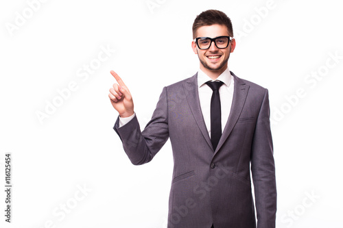 Handsome smiling businessman pointing finger away over gray background