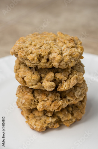 Stack of four oatmeal cookies on white plate