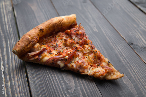 slice of pizza on a wooden background
