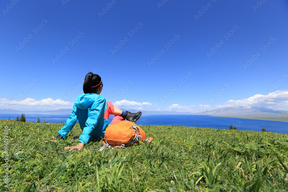 young woman hiker sitting on a grass mountain top with first person perspective view young woman hiker sitting on a grass mountain top with first person perspective view